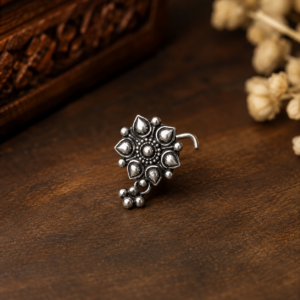 Home Make a bold statement with this South Indian-inspired silver nose pin, featuring an intricate traditional design with a contemporary edge. Lightweight, elegant, and perfect for adding a distinctive touch to your everyday or festive look.